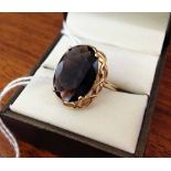 9ct gold ring set with very large oval smokey quartz stone in a pierced mount. Size R½.