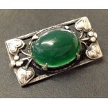 Silver Art Nouveau brooch with oval green cabouchon.