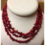 3 string red agate necklace with white metal beads.