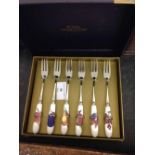 A boxed set of Royal Worcester Evesham gold pastry forks with ceramic handles.