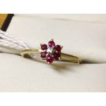 Ladies 9ct gold dress ring with flower design set with central diamond enclosed by garnets. Size