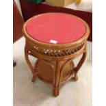 A red leather topped round conservatory table