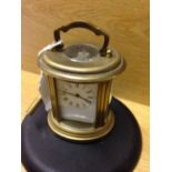 Miniature brass oval carriage clock.