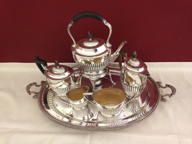 A composite 5 piece silver tea service all in the same half fluted oval shape with ebony handles and