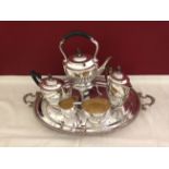 A composite 5 piece silver tea service all in the same half fluted oval shape with ebony handles and