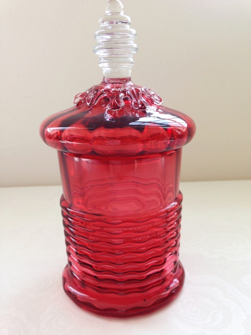 An antique Victorian cranberry glass barrel shaped lidded jar with clear glass finial, pontil mark