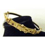 A 9ct gold Victorian bangle designed as a belt buckle and set with a diamond and 2 rubies.