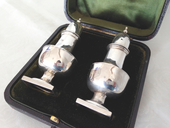 A cased pair of silver pepper casters, Birmingham 1873. Approx 76g.