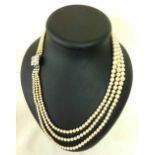 A vintage cased 3 string faux pearl necklace with baguette diamante clasp. Approx 22 inches.