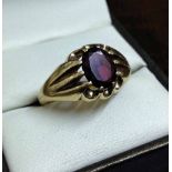 A vintage 9ct gold 'gypsy' ring set with an oval garnet. Approx 5.1g, size V.