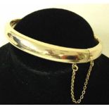 A 9ct gold Victorian smooth bangle with safety chain approx. 10.9g - not hallmarked, tests as 9ct.