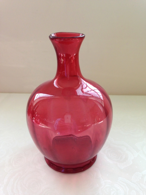 An antique cranberry glass vase with internal fluted decoration and pontil mark to base.