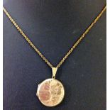 A 9ct gold round locket with engraved flower design to front on a 9ct chain 22" - Total approx