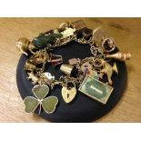 A 9ct gold charm bracelet set with 30 charms (majority 9ct gold) to include seal with Pegasus design