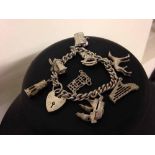 Silver charm bracelet with heart shaped padlock clasp and 8 substantial charms, weight approx 38.2g