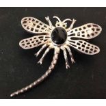 Silver dragonfly brooch set with oval Whitby jet cabouchon.