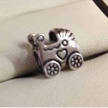 Pandora silver baby carriage charm.