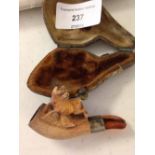 A small carved meerschaum pipe with dog on top of bowl, in original case.