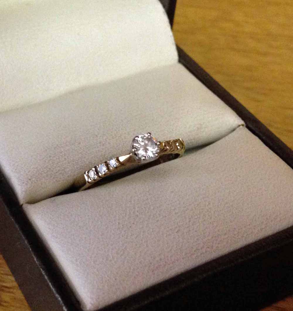 Hallmarked 9ct gold ladies ring with 0.25ct diamond and diamond set shoulders. Size L.