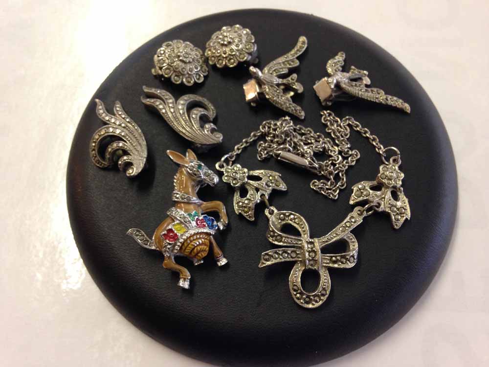 A collection of marcasite jewellery: 3 pairs of clip on earrings, a necklace and a donkey brooch.