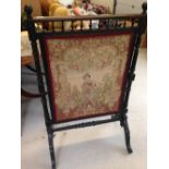 A large Victorian tapestry fire screen with turned wood supports and stretcher and galleried top.