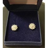 A pair of 9ct gold & diamond cluster earrings.