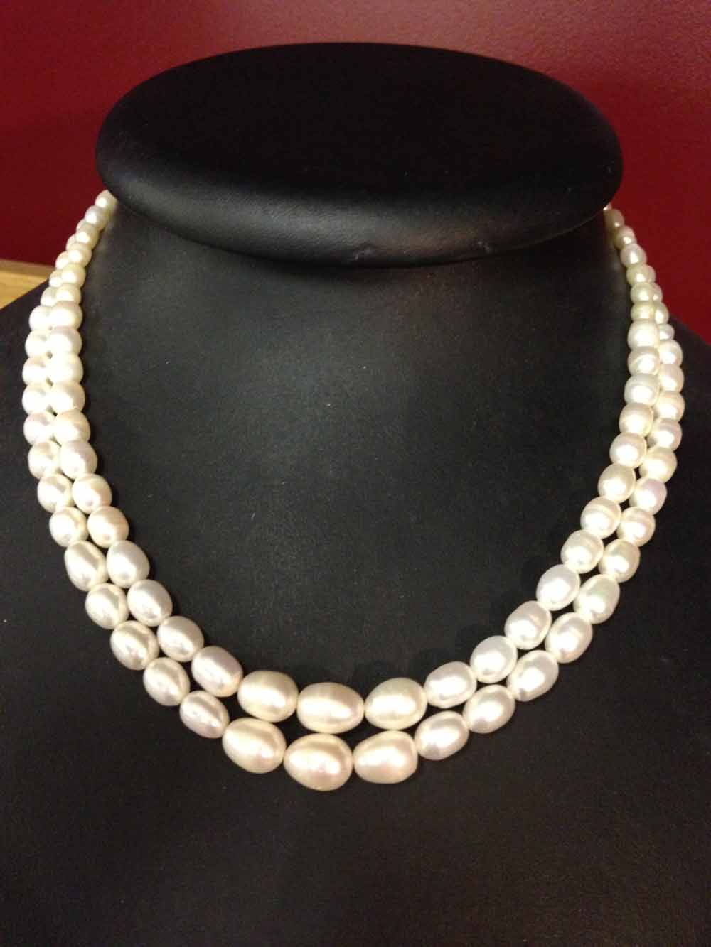 Double string freshwater pearl necklace, pearls of oval shape with graduated sizes.