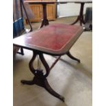 A leather topped coffee table with lyre shaped ends.