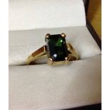 A 9ct gold ring set with an emerald cut green stone size M, approx 2.8g.