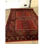 A large vintage red patterned wool carpet. Approx 290 x 200cm.