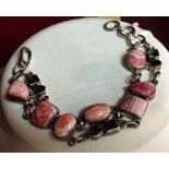 925 silver bracelet set with polished & cut rhodochrosite stones. One small stone missing.