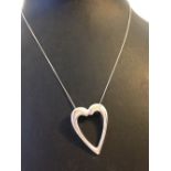 A 925 silver open heart shaped pendant set with a small diamond, on a silver chain.