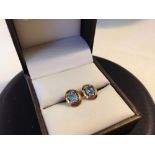 Pair of gold earrings set with oval blue topaz stones, tests as 9ct.