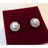 A pair of vintage pearl and diamond stud earrings - approx 20 diamonds set around a single pearl.