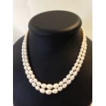 Double string freshwater pearl necklace, pearls of oval shape with graduated sizes.