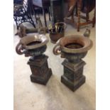 A pair of cast iron garden planters 52cm tall.