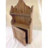 A small pine wall cabinet with key.