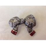 Silver marcasite brooch in the shape of a bow, set with 8 red garnets.