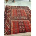 A large vintage red patterned wool carpet. Approx 290 x 200cm.