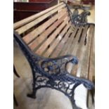 A garden bench with black cast iron ends and wooden slats, 127cm wide.