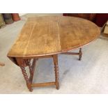 An antique oak gateleg table with barley twist legs, 107cm x 150cm when open.