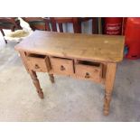 A vintage pine side table with 3 drawers.