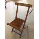 An old wooden childs folding chair, approx 60cm tall.