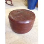 A vintage brown leather pouffe.