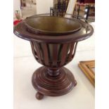 A wooden ice bucket with brass liner.