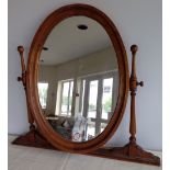 A large French oak oval dressing table mirror.