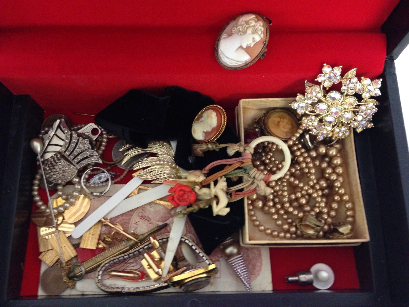 A black jewellery box containing costume jewellery & other items to include cameo brooch & choker,