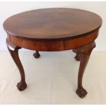 A walnut veneered circular table with ball & claw feet.