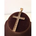 A large gold cross set with white stones measures approx 4cm long or 5.5cm to the top of the ring.