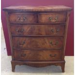 A 2 over 3 walnut veneered chest of drawers.